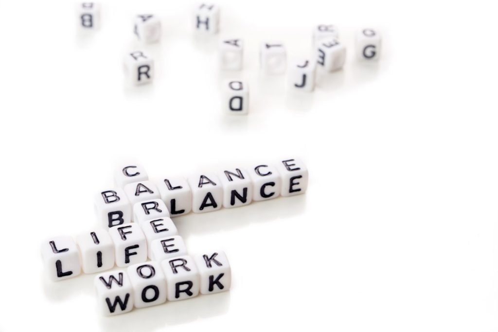 little white dices with black letters forming a crossword with the theme work life balance as equilibrium of professional and personal family life on white background