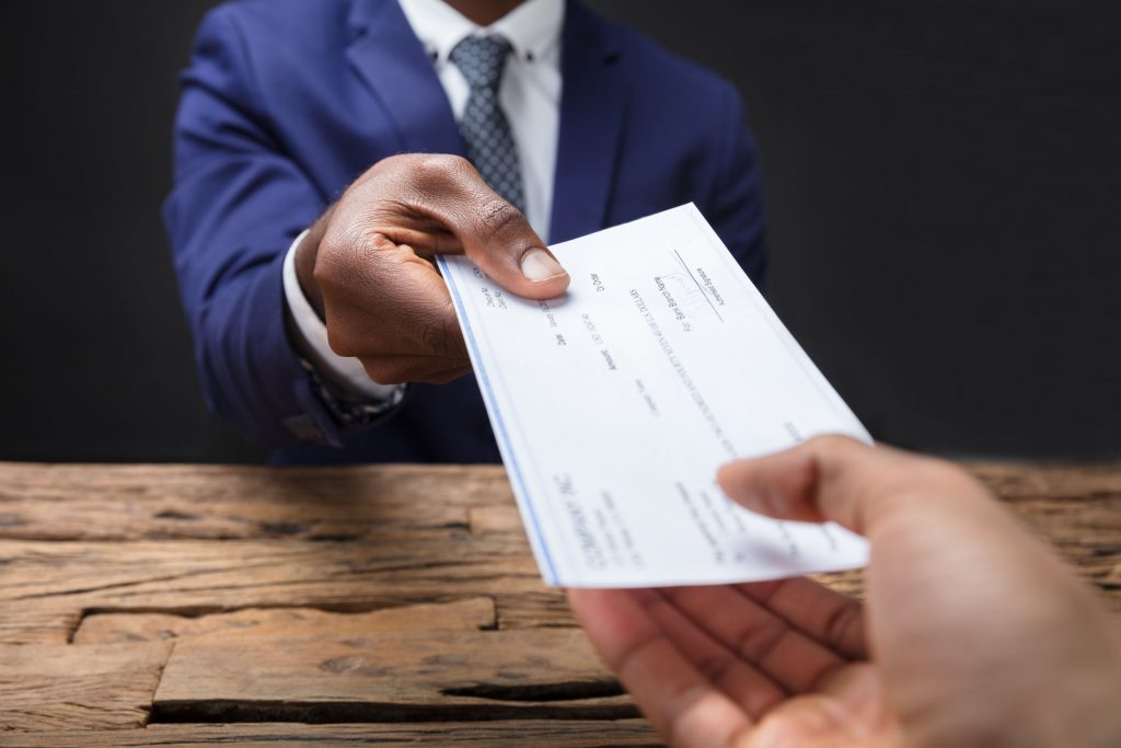 Businessman Giving Cheque To His Colleague