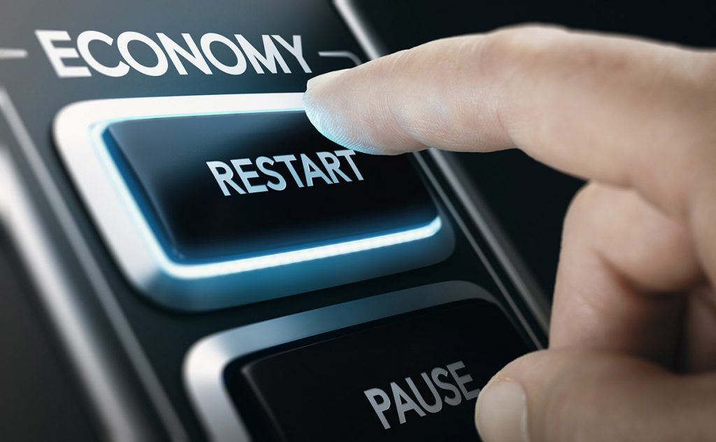 Man pressing a button to restart national economy after crisis. Composite image between a hand photography and a 3D background.