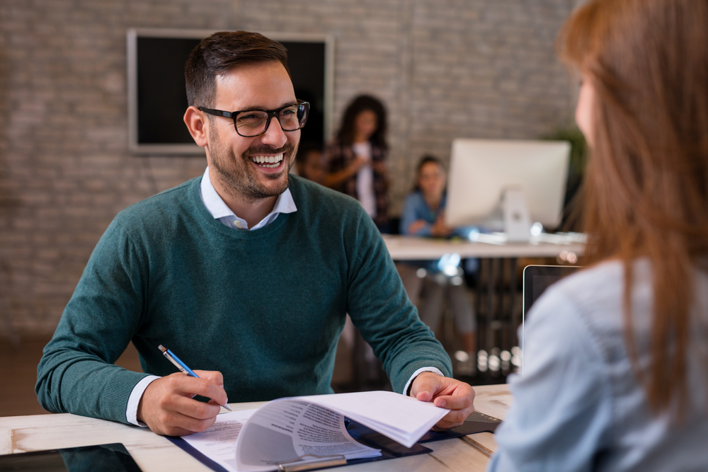 Caucasian man interview brunette woman for job.