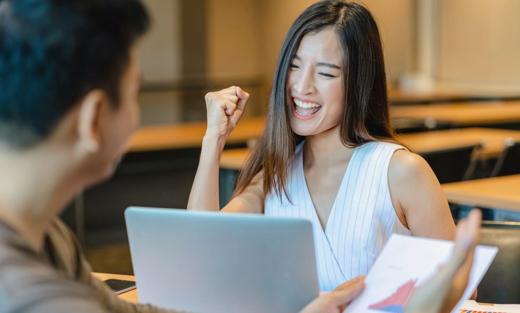 Rear view of Boss congratulating to asian businesswoman in glad action when successful project or getting promote, rewarding the business target in modern office, successful business concept